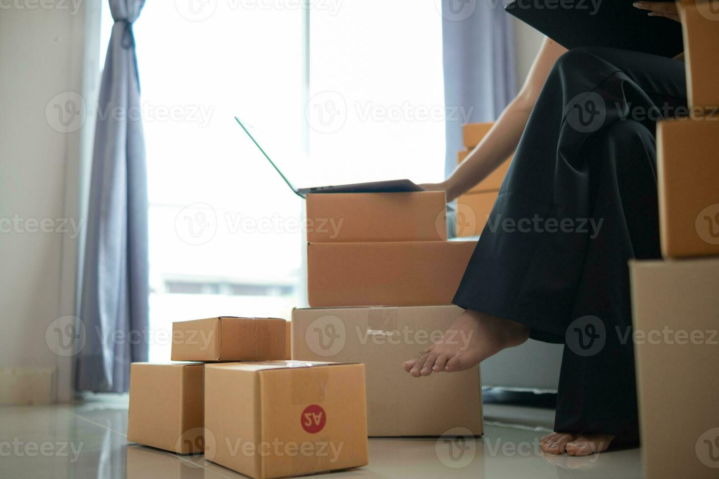 Frau Überprüfung Paket von Waren von Kunde online bestellen ist allein im ihr Zuhause Büro wie sie ist ein sme Unternehmer und Verwendet ihr Telefon und Tablette zu Markt online. Konzept online Der Umsatz Geschäft foto