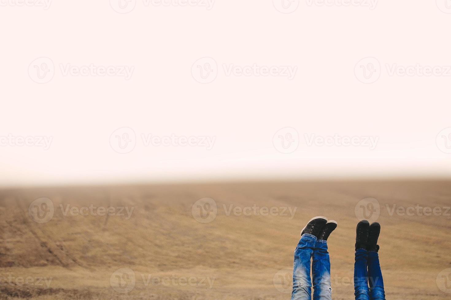 eine Frau und ein Mann Füße hoch in die Luft erhoben. im Herbst im Feld schießen. Platz für die Inschrift foto