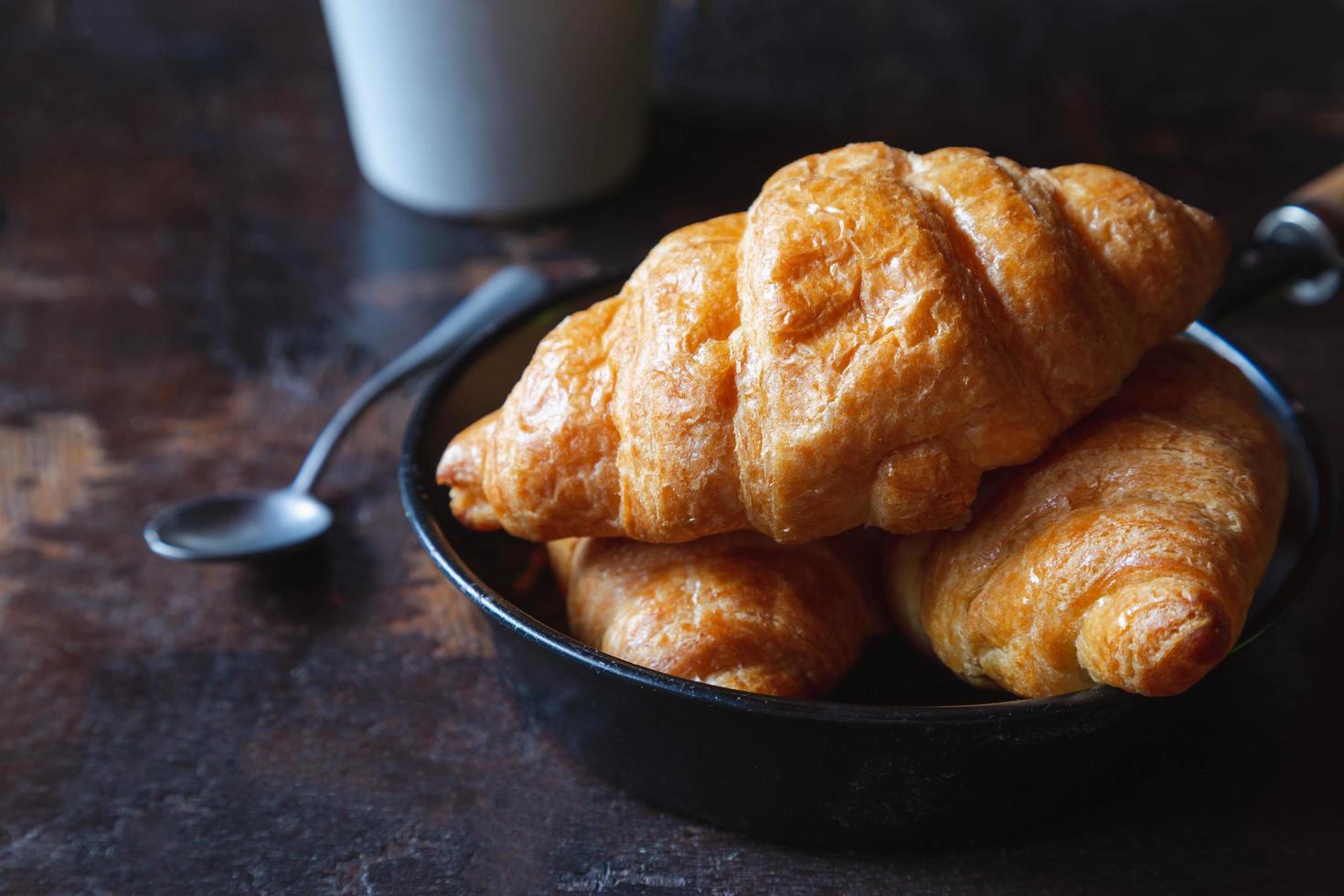 Frühstücksbrot, Croissants und frische Milch auf dem Holztisch. foto