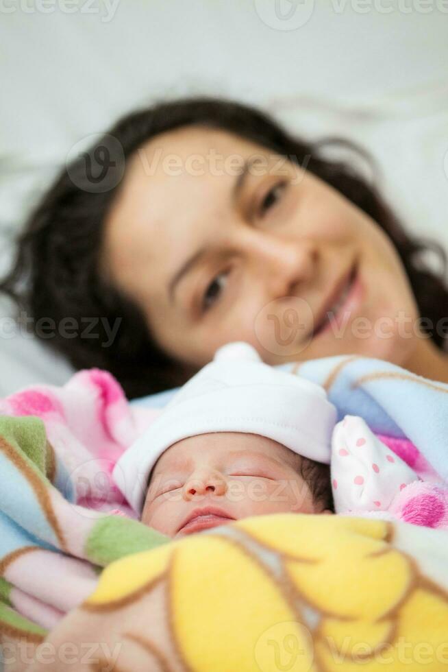 Neugeborene Mädchen mit ihr Mama im das Krankenhaus auf das Tag von ihr Geburt. Mutterschaft Konzept foto