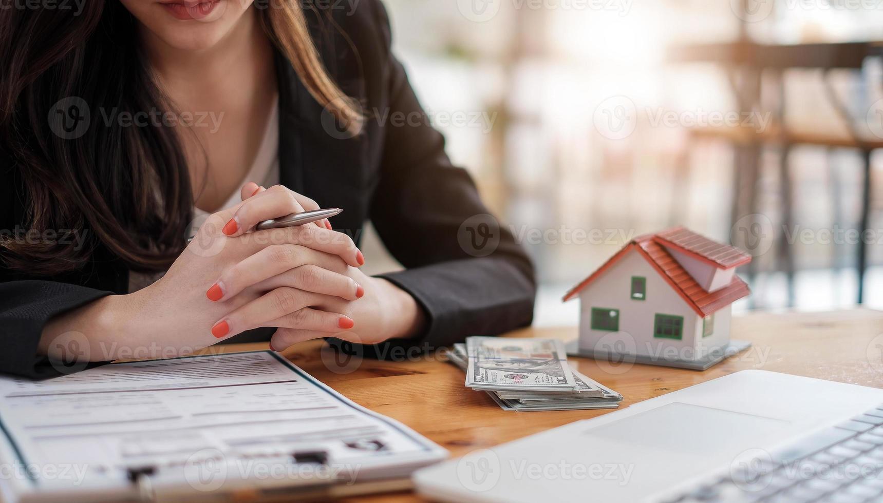 Immobilienmakler mit Hausmodell-Hand, die den Vertrag unterzeichnen, einen Vertrag zum Schutz abschließen, bescheidene Vereinbarungen im Büro unterzeichnen. Immobilienkonzept, Umzug oder Miete von Immobilien foto