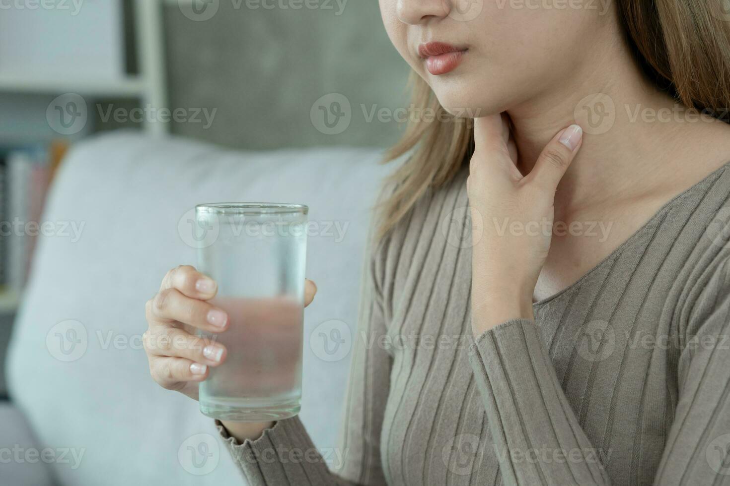 Aisa Frau stellen ihr Hand auf ihr Hals fällig zu ein wund Kehle. weiblich Mandelentzündung Ursachen ein Entzündung. behandelt durch nehmen Wasser, nehmen Antibiotika, konsultieren ein Arzt, Virus, Corona Virus, Grippe, Grippe foto