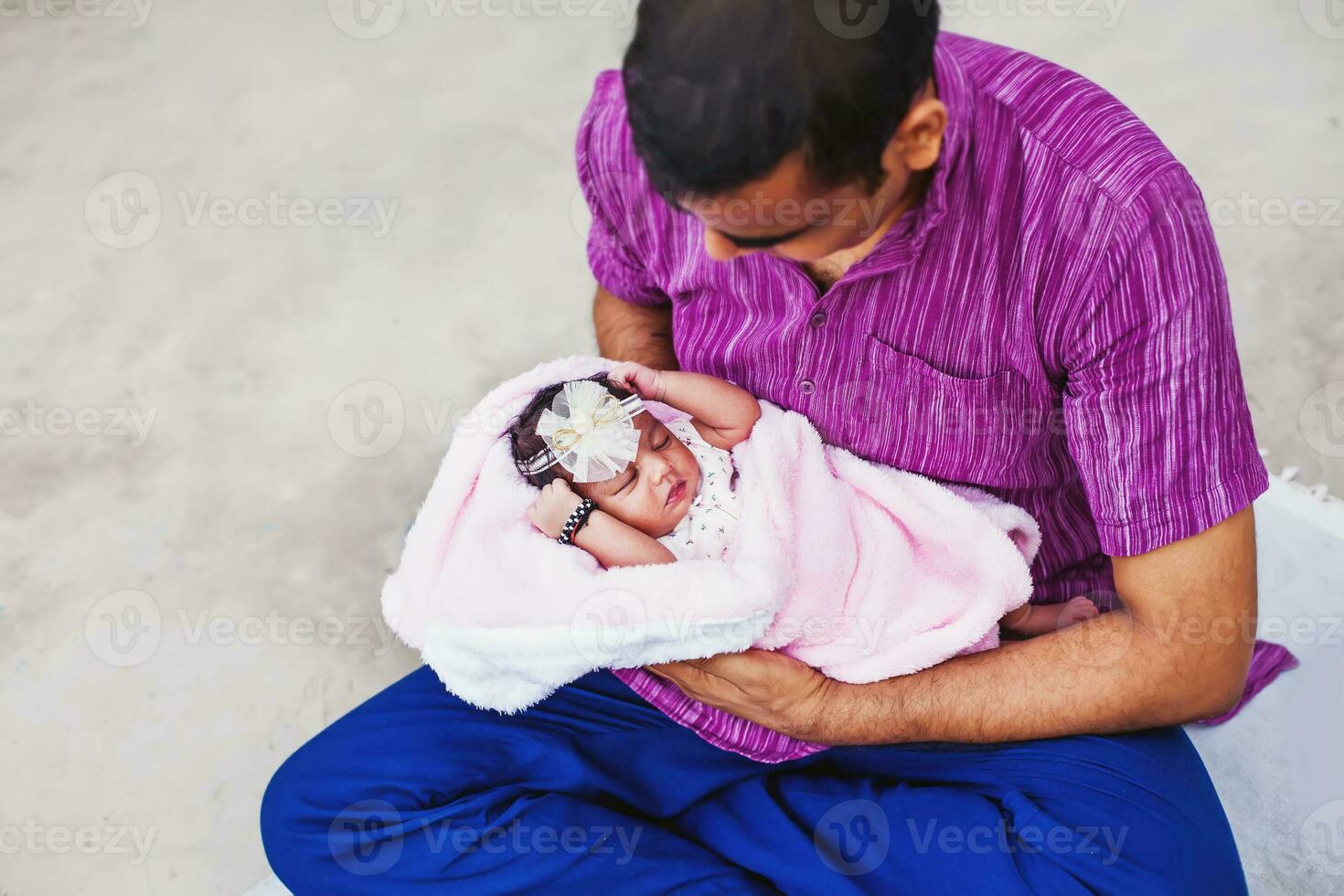 ein Mann halten ein Baby im ein Rosa Decke foto