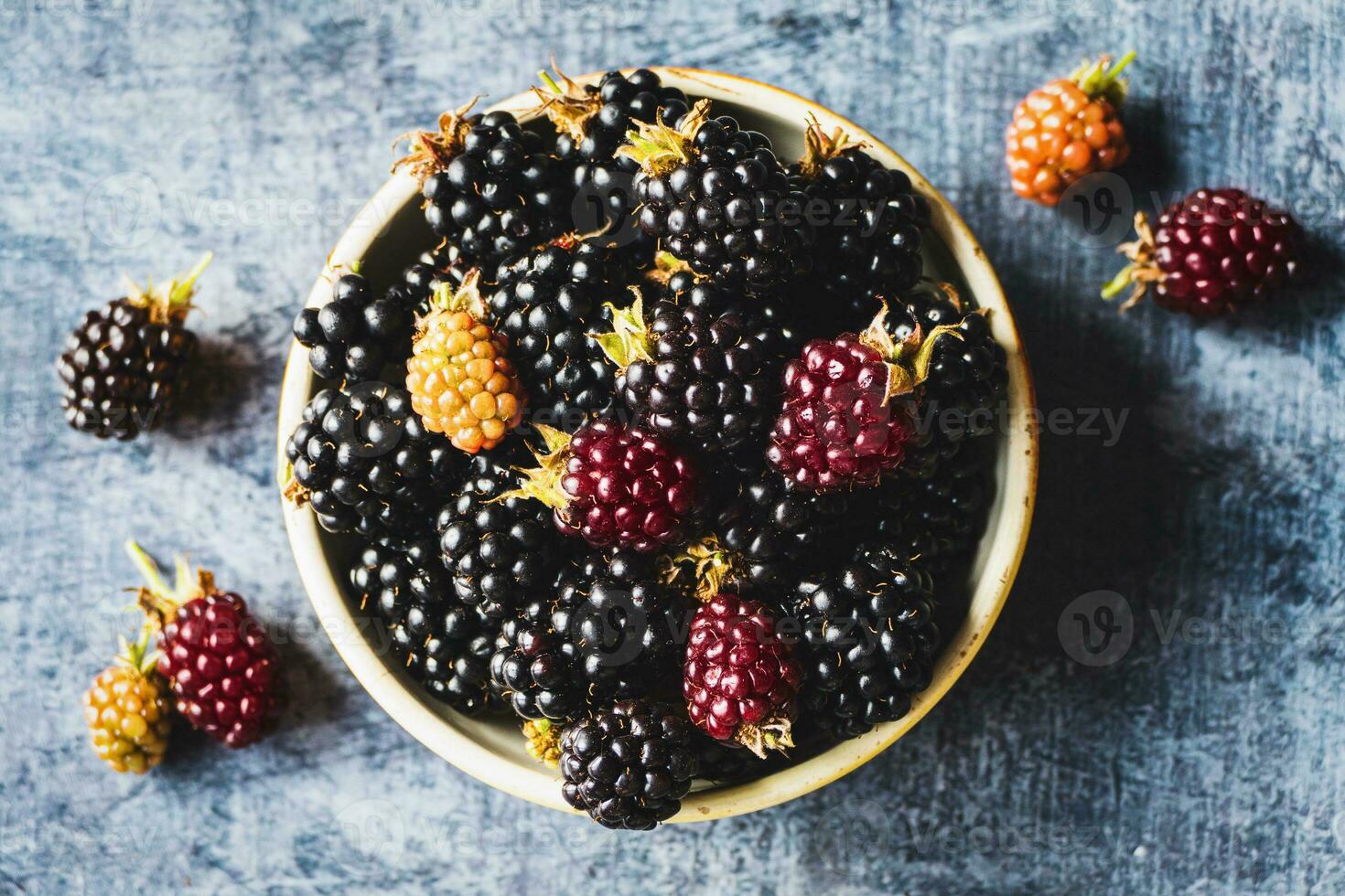 Brombeere Früchte Schüssel Overhead Aussicht Sommer- Essen Hintergrund, reif Brombeeren auf grau Tabelle foto