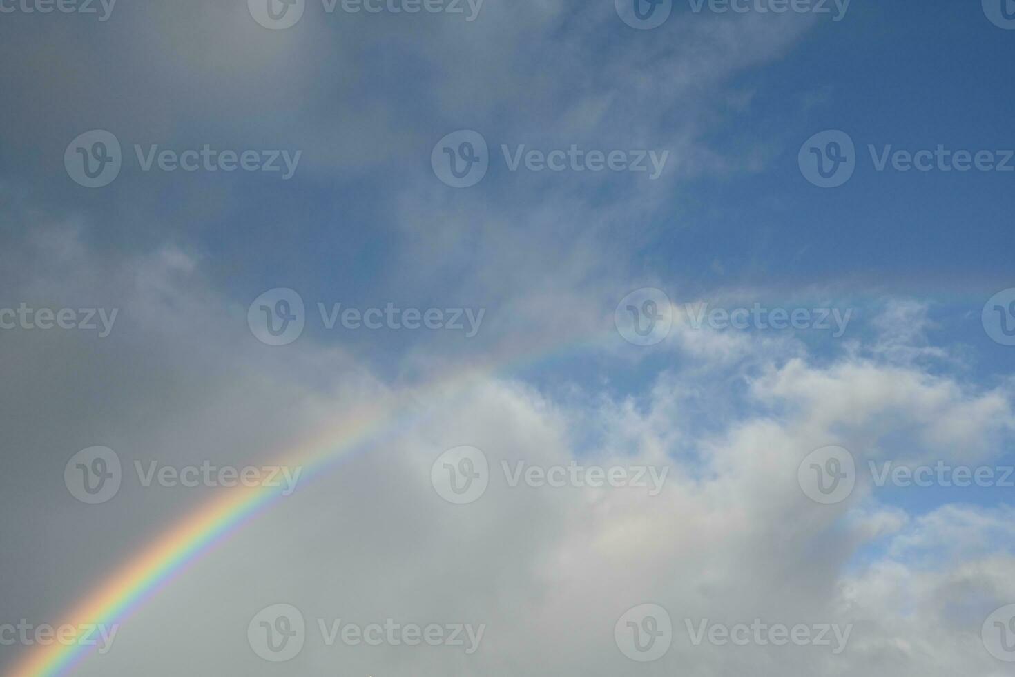 das Wolken sind dünn, aber das Regen schafft ein Regenbogen über das Horizont. foto