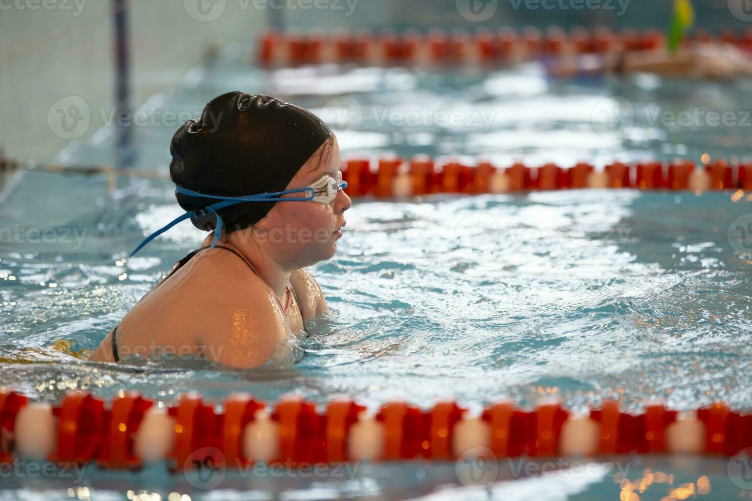 Kind Athlet schwimmt im das Schwimmbad. Schwimmen Abschnitt. foto