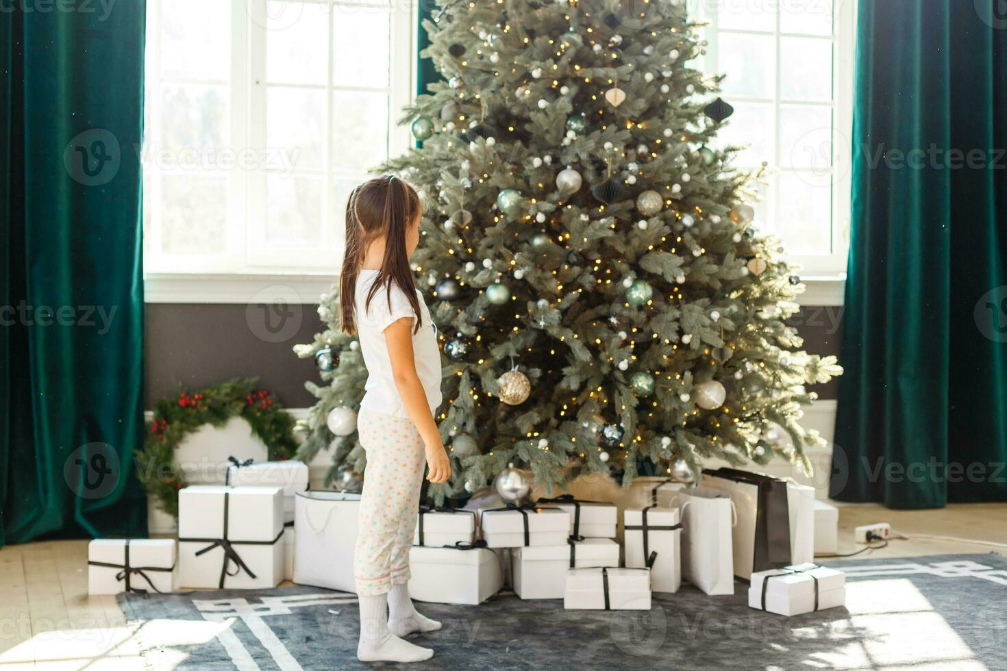 glücklich wenig Mädchen mit Weihnachten Baum foto