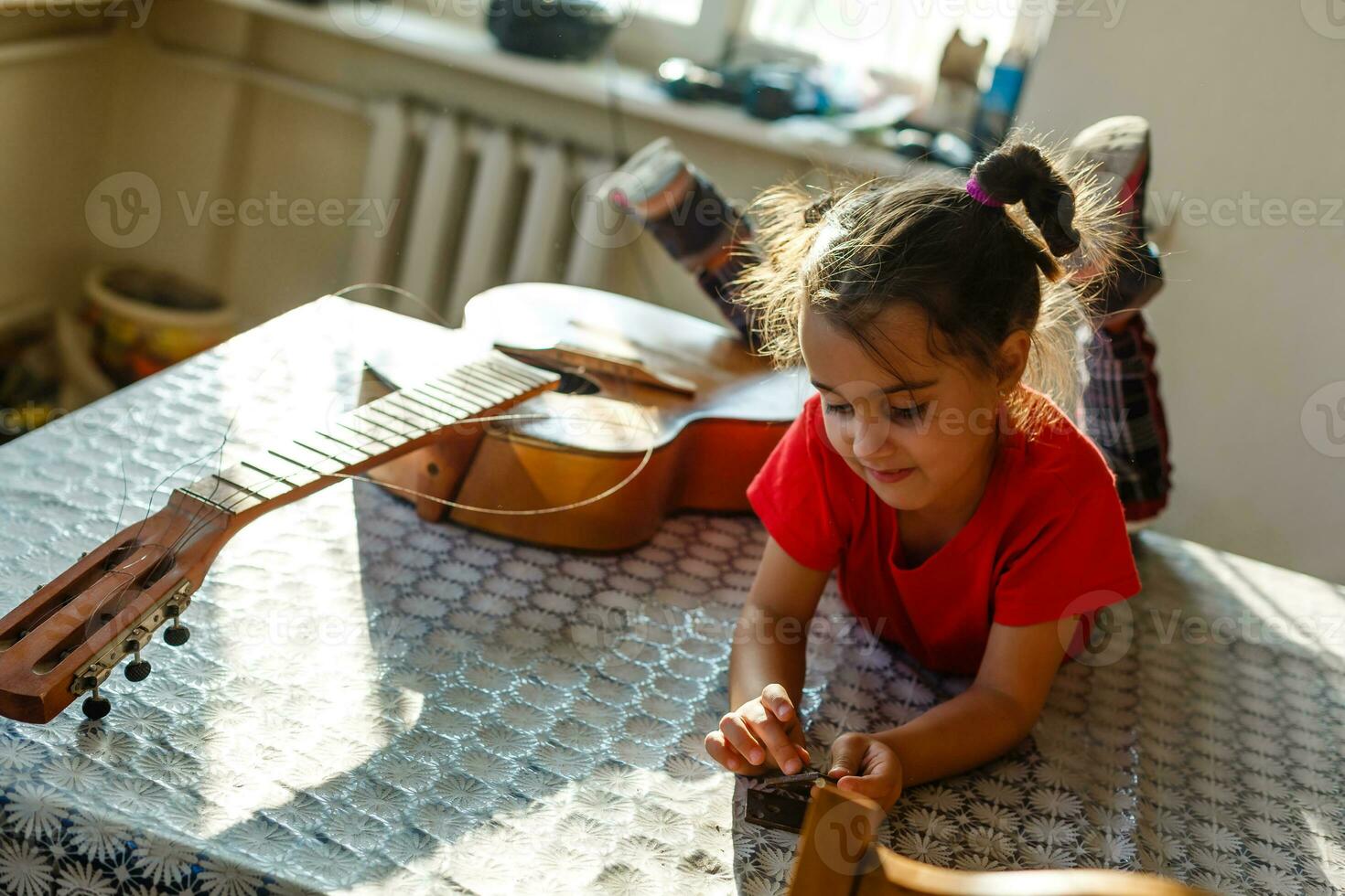 wenig Mädchen halten ein gebrochen Gitarre, Gitarre Reparatur foto