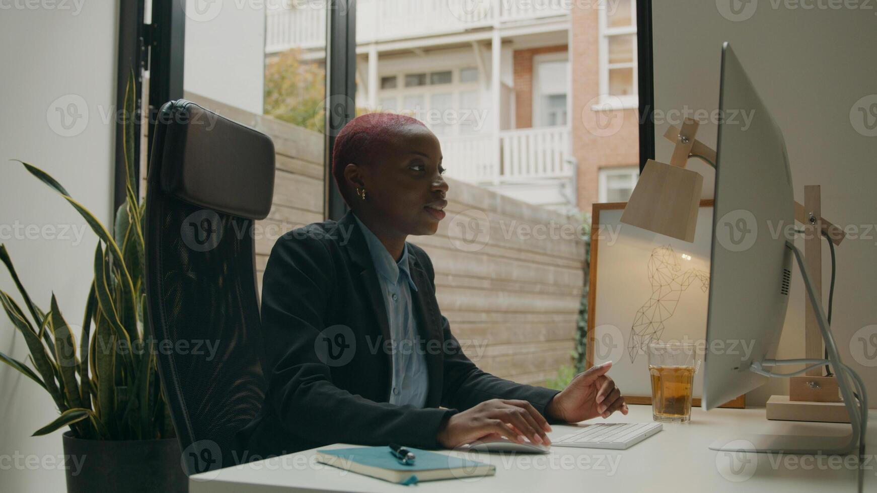 junge Frau im Videotreffen am Computer am Schreibtisch foto