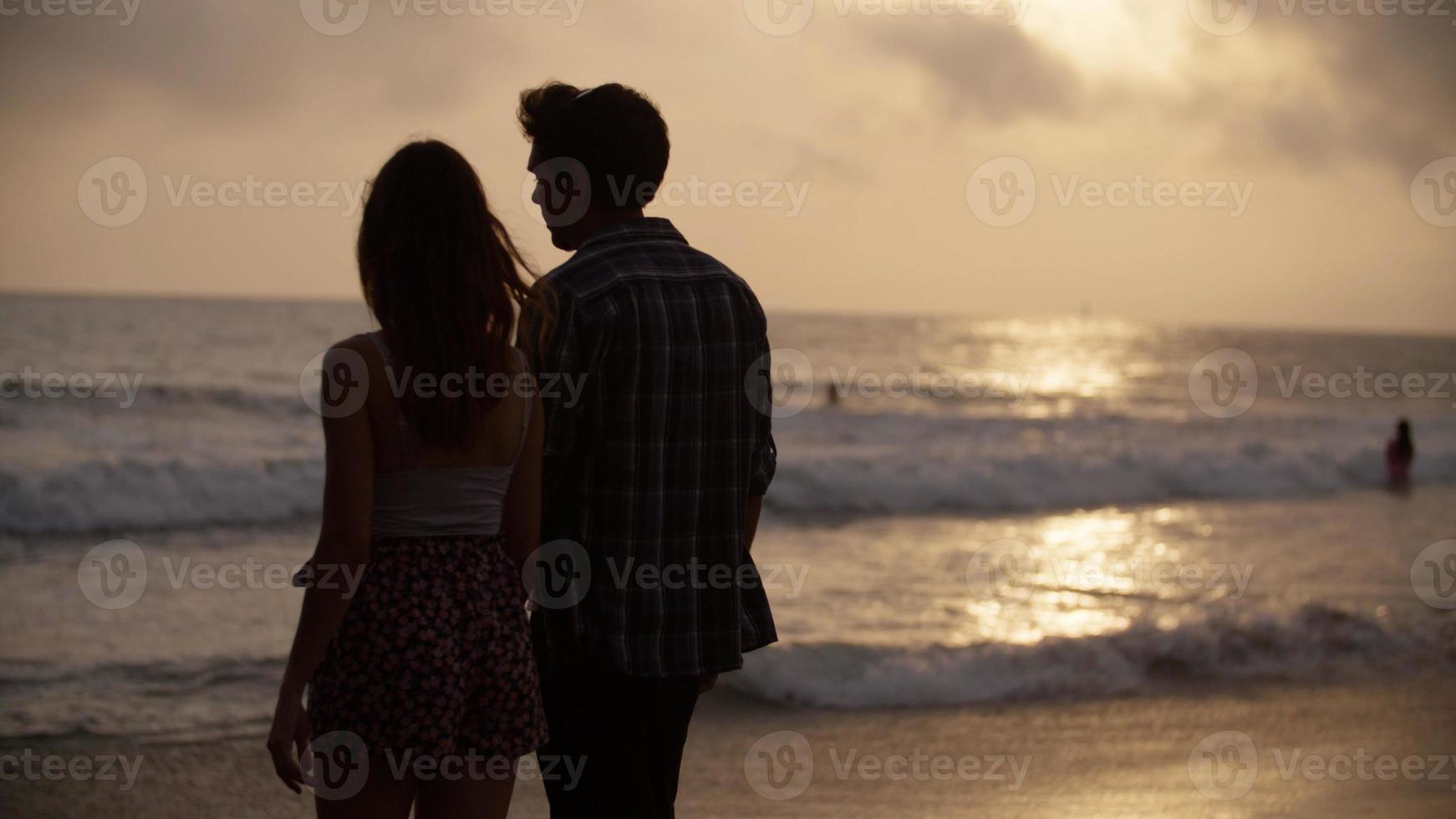 Porträt des jungen Paares Händchen haltend am Strand foto