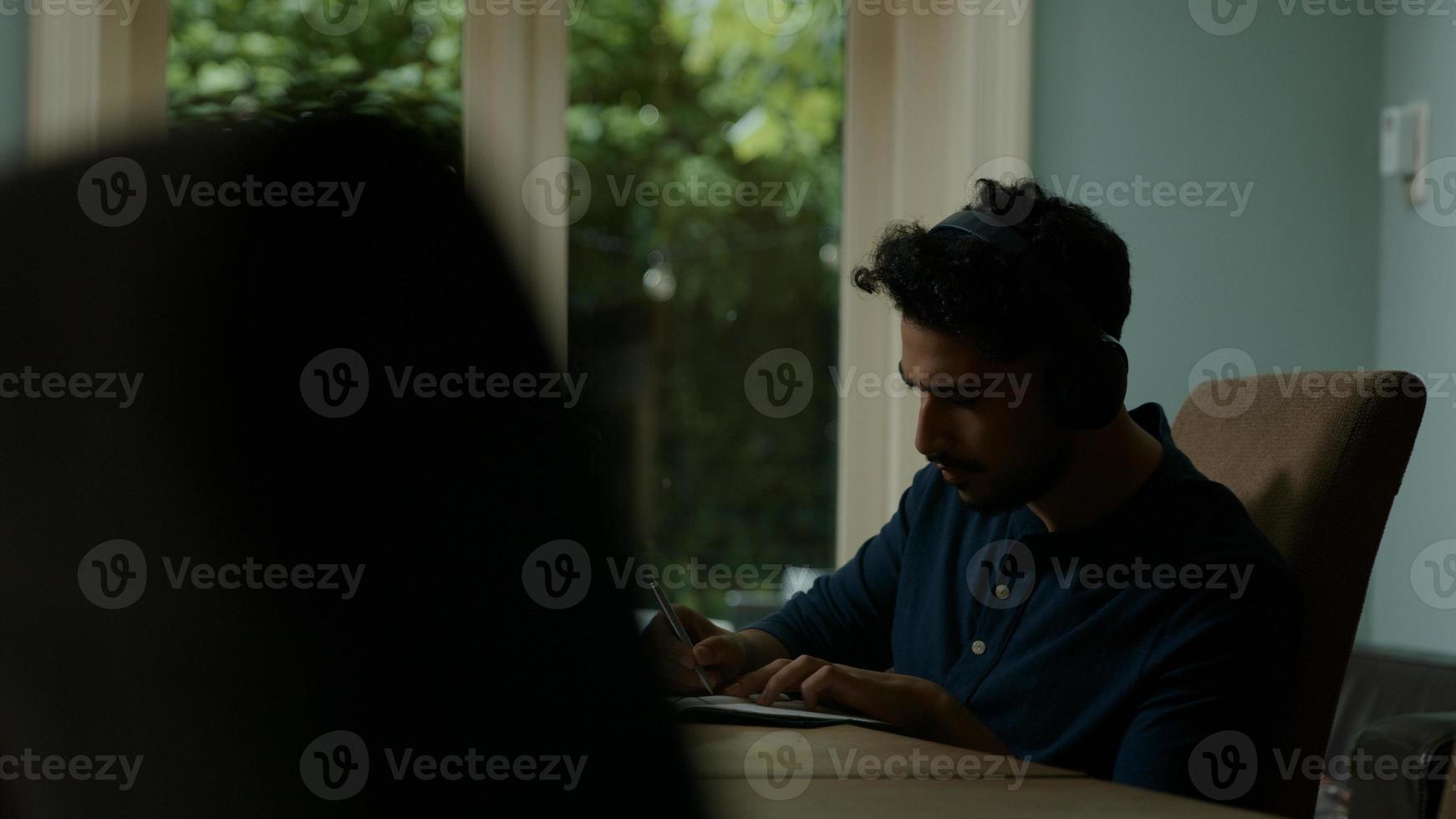 junger Mann, der Online-Treffen zu Hause mit Tablette hat foto