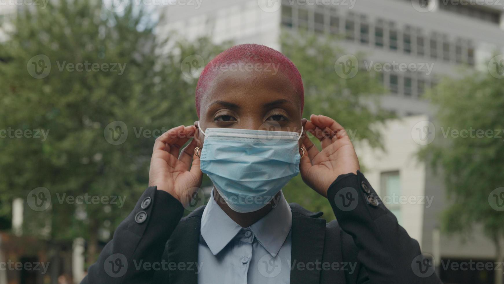 Porträt einer jungen Frau, die eine schützende Gesichtsmaske aufsetzt foto