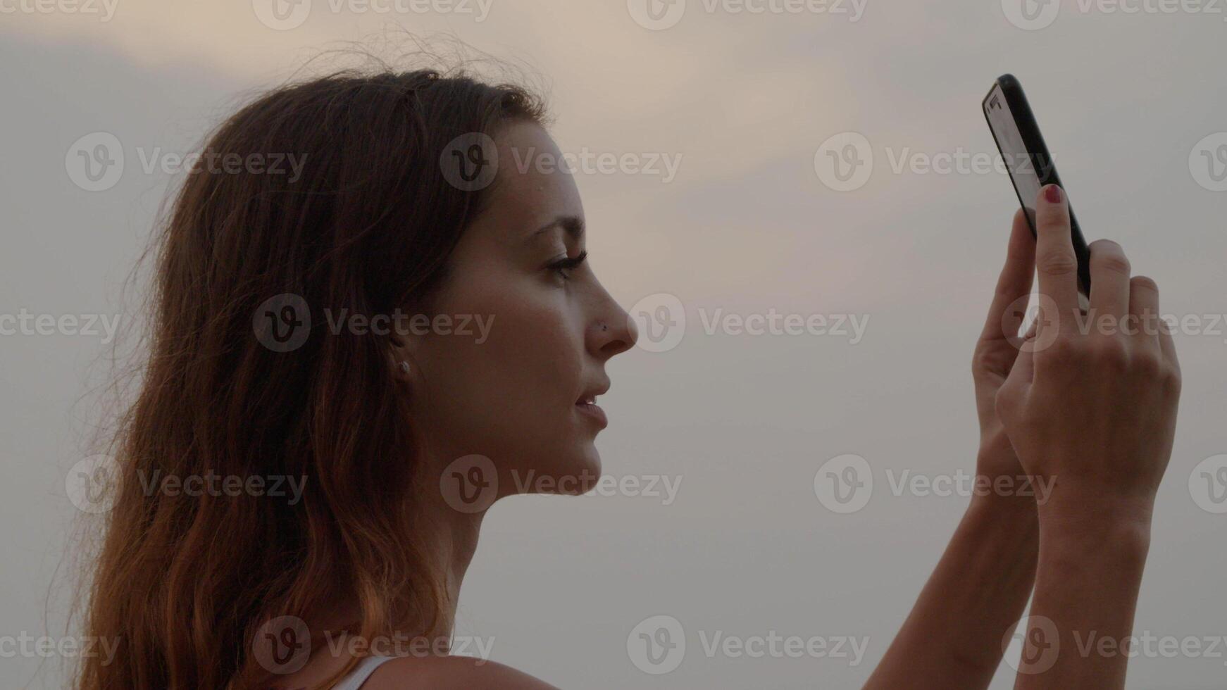 Porträt einer Frau, die ein Foto am Telefon macht