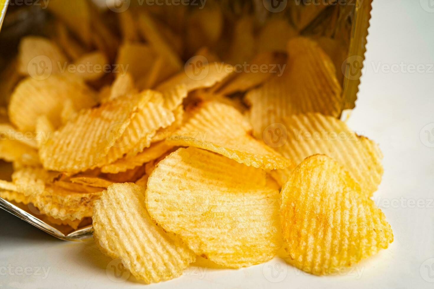 Kartoffelchips, leckeres Grillgewürz würzig für Crips, dünne Scheiben frittierter Snack Fast Food im offenen Beutel. foto