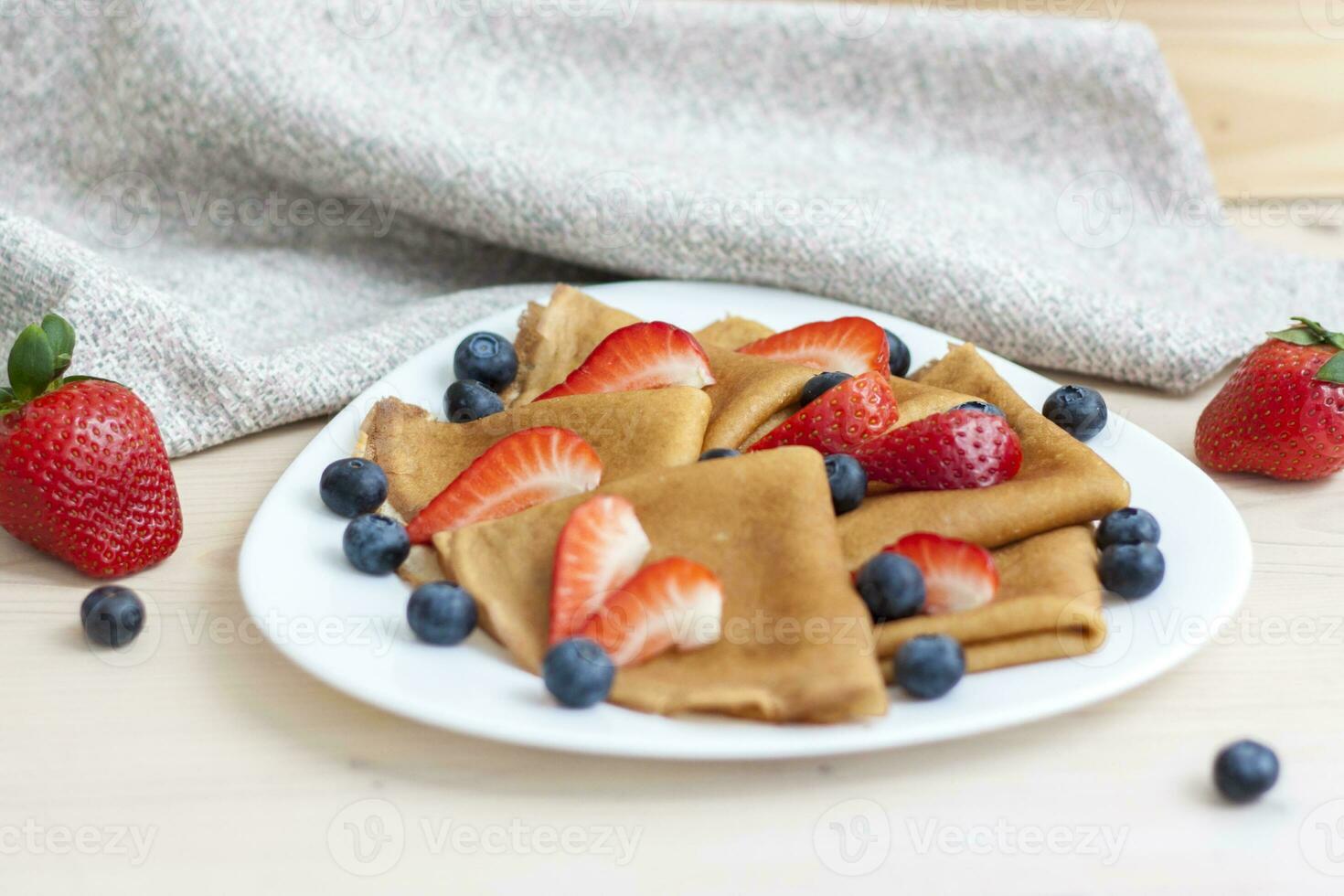 Pfannkuchen mit Blaubeeren und Erdbeeren auf das Tisch. traditionell Essen zum maslenitsa foto