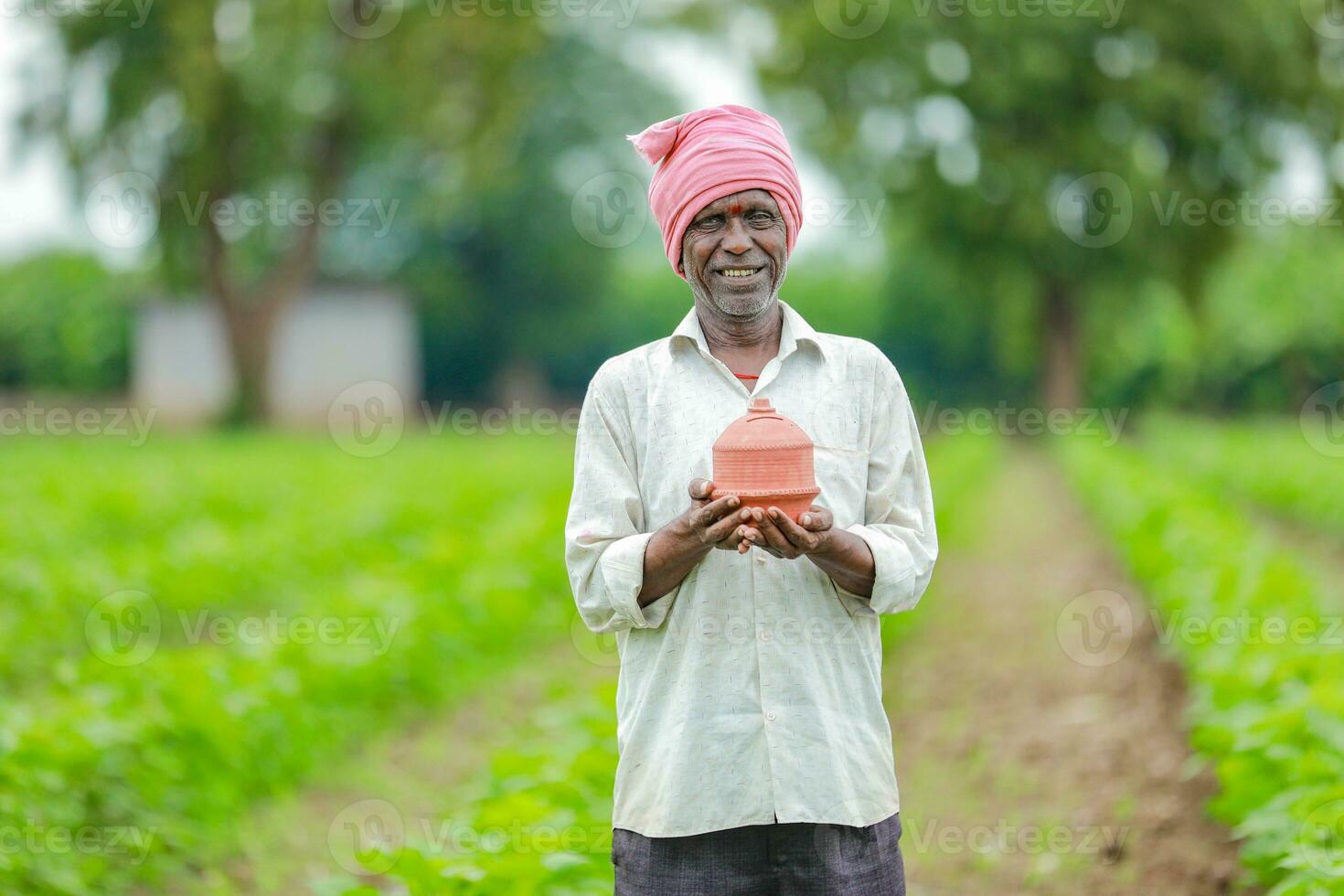 indisch Farmer halten gullak im Hand, Speichern Konzept, glücklich Arm Farmer foto