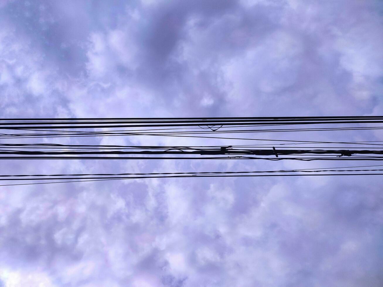 Gewirr von Drähte und Kabel auf Wolken Hintergrund. unordentlich Elektrizität Drähte und Kabel. foto