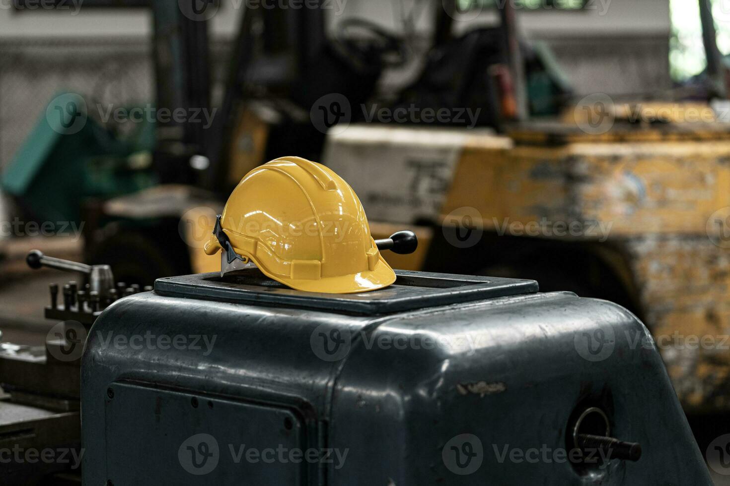 Gelb Helm mit Maschinen, das Hintergrund ist Fabrik foto