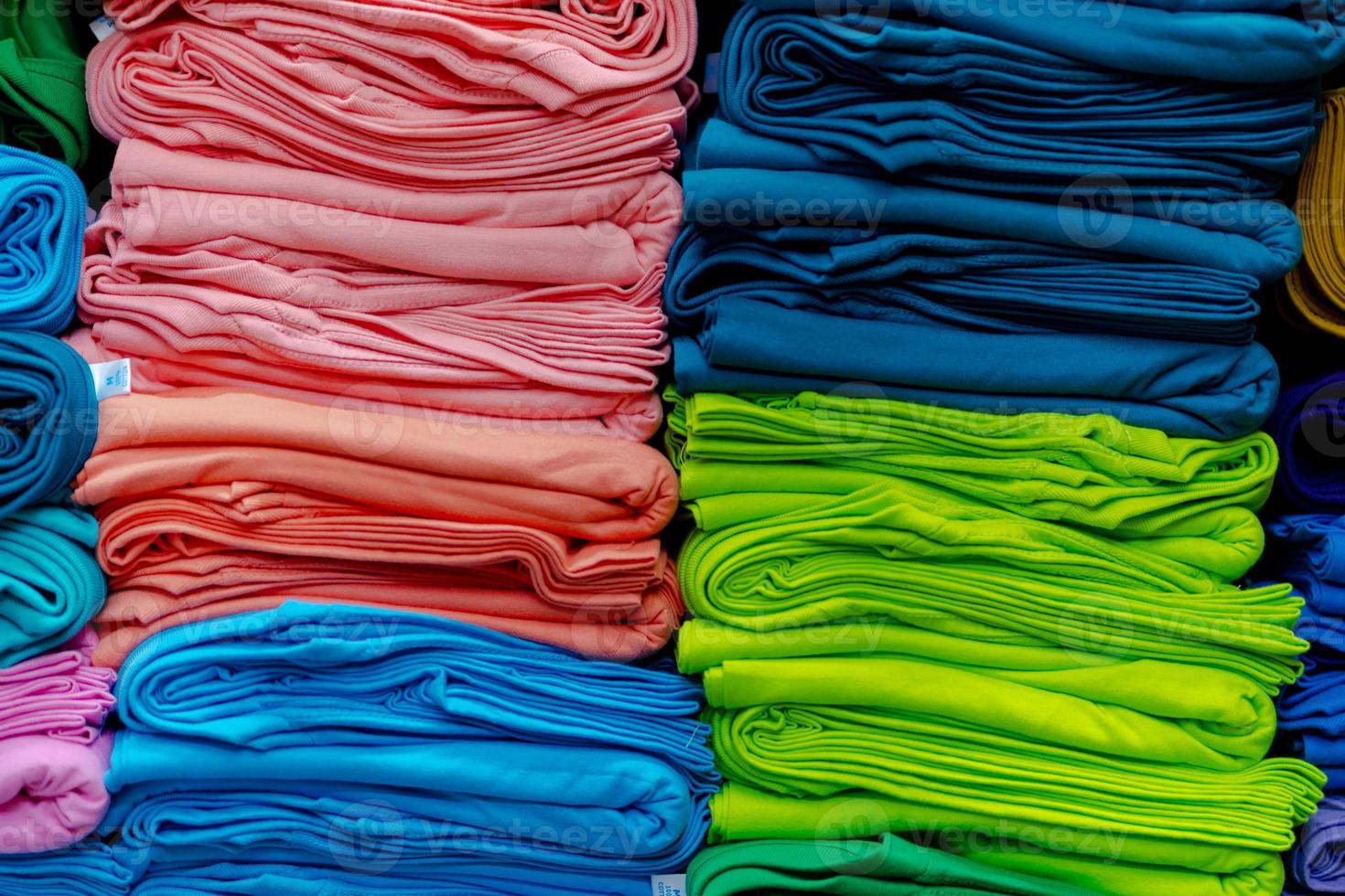 Nahaufnahme von bunten T-Shirts in Regalen gestapelt foto