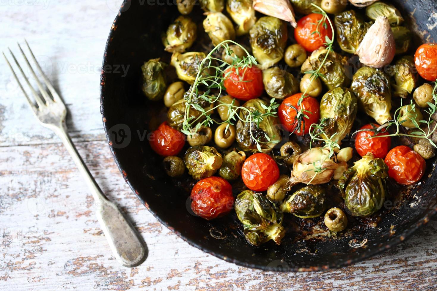 Rosenkohl mit Gemüse und Kräutern in einer Pfanne foto