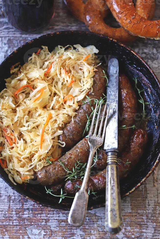 bayerische Würstchen in der Pfanne mit gedünstetem Sauerkraut oktoberfest Essen foto