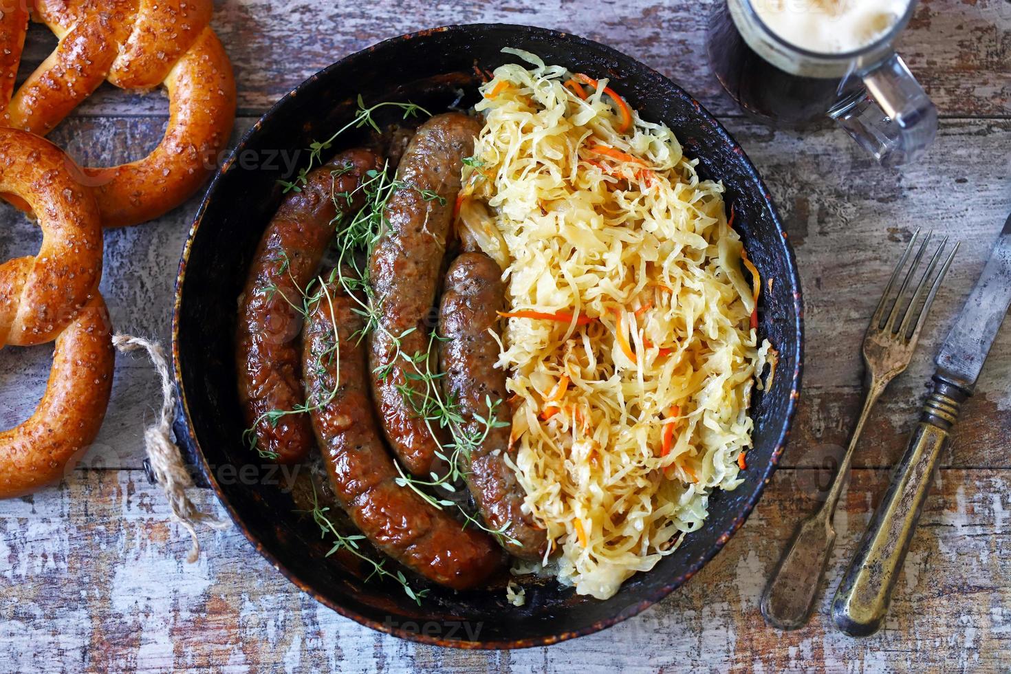 bayerische Würstchen in der Pfanne mit gedünstetem Sauerkraut oktoberfest Essen foto