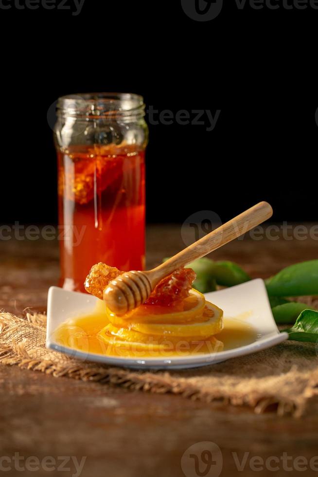 Zitronensaft mit Honig auf Holztischzitronen und Salbeiblättern foto