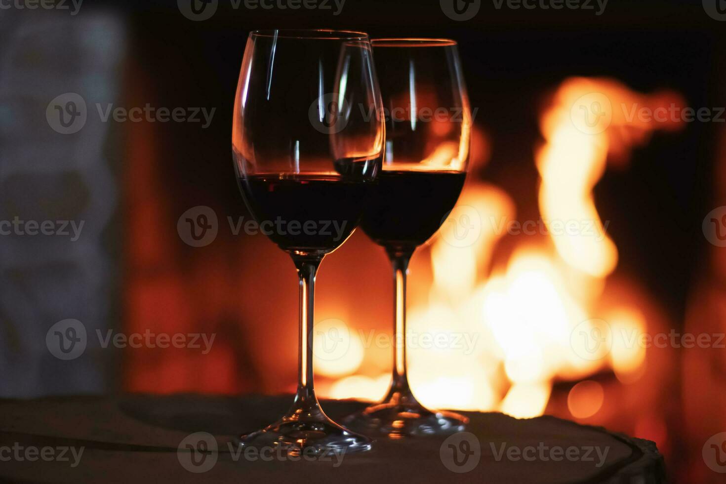 rot Wein im Vorderseite von ein Kamin, entspannend Atmosphäre foto