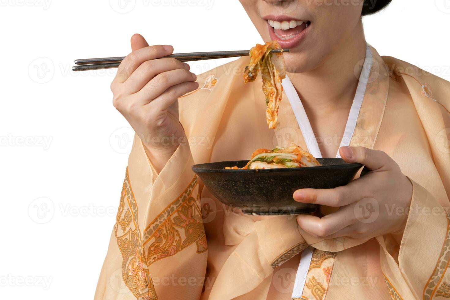 asiatisch Frauen tragen Koreanisch Hanbok, halten Kimchi Schüssel und Essen Kimchi mit ein Stäbchen. foto