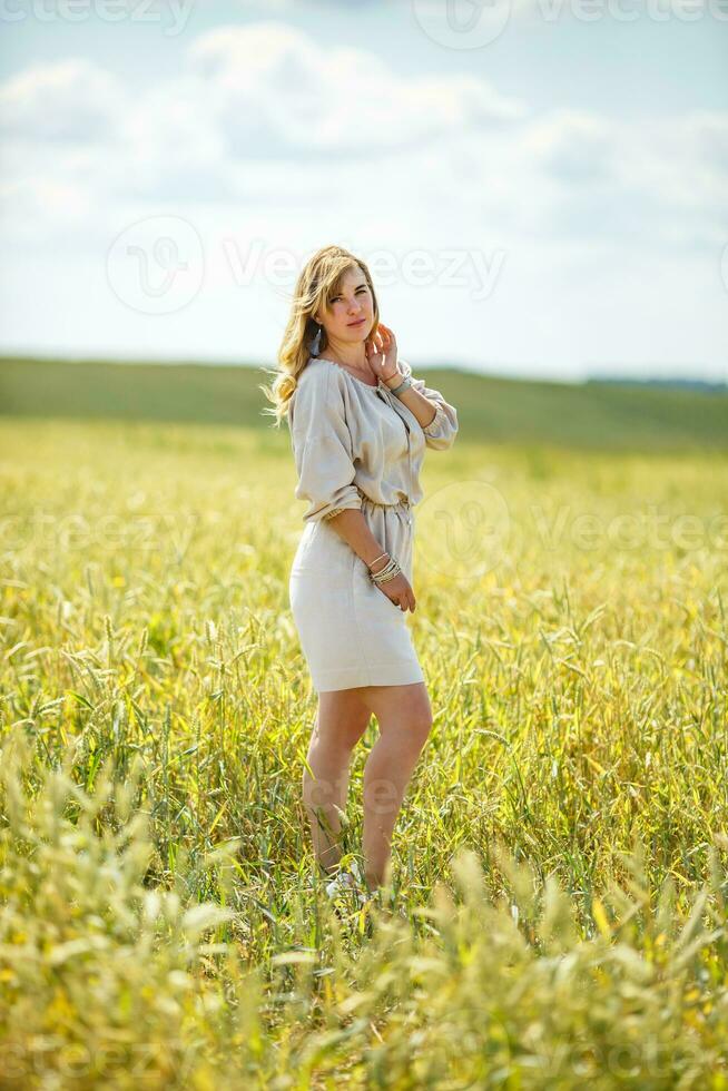 schön Mädchen im ein Leinen- Kleid im ein Weizen Feld foto
