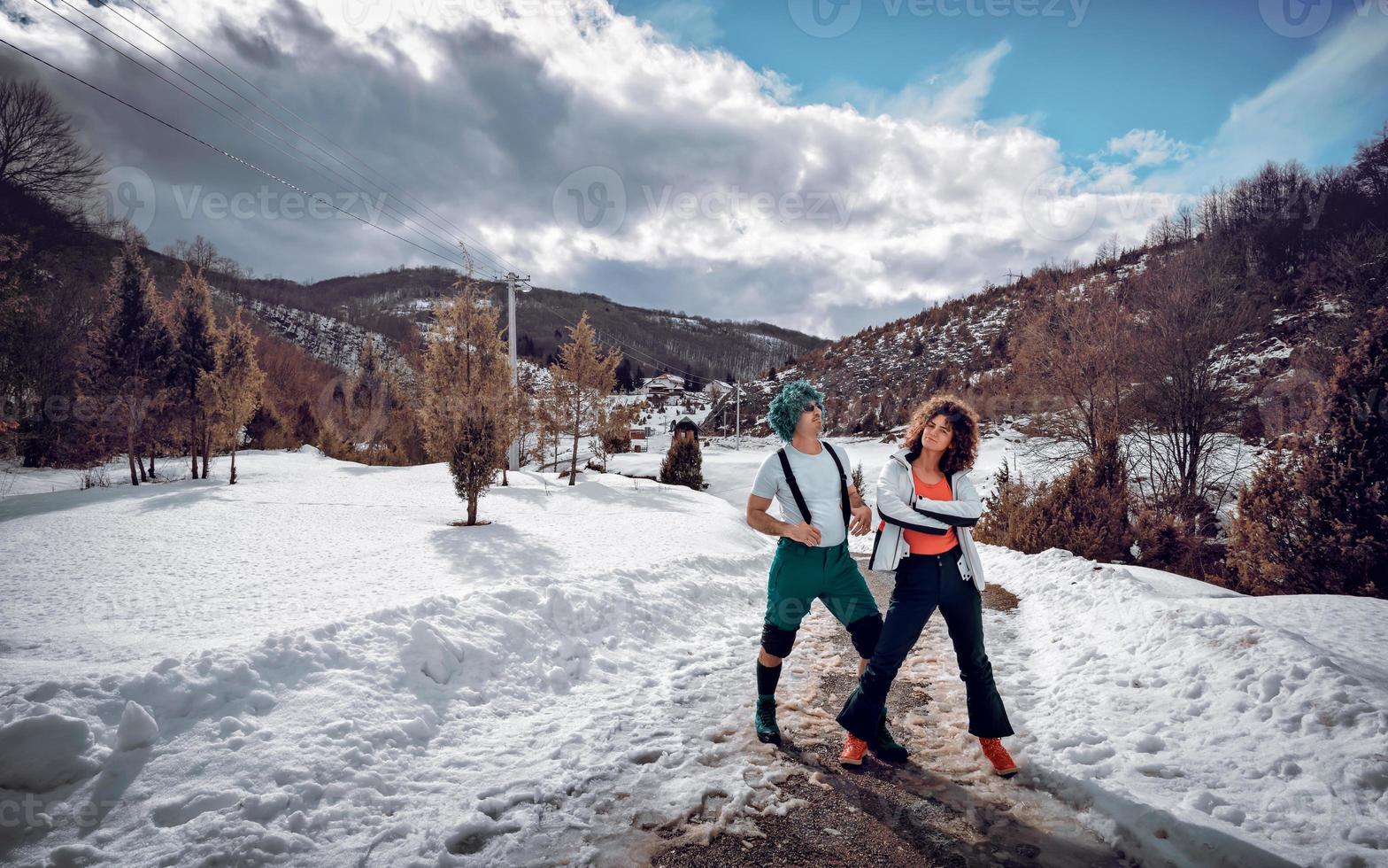 Ein verliebtes Paar steht und hat Spaß im Schnee an einem sonnigen Wintertag. foto