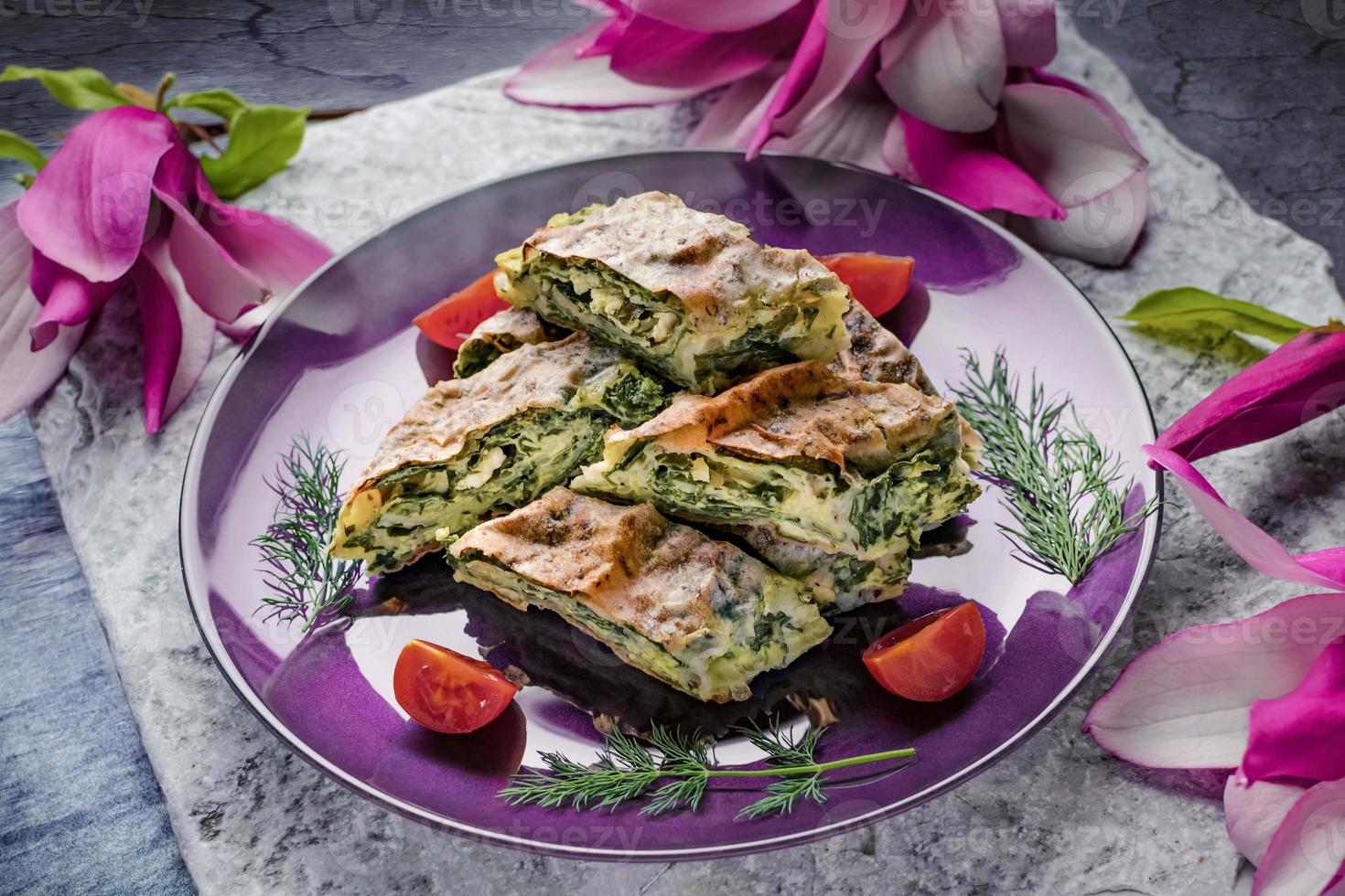 Spinatkuchen mit Kirschtomaten nach traditioneller Art zubereitet foto