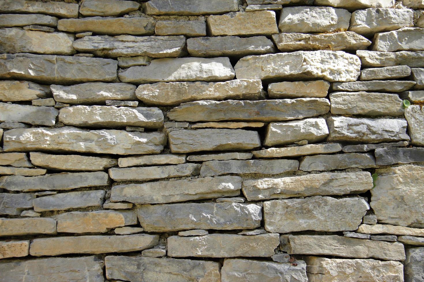 Dekorativer Hintergrund der alten Steinmauer foto