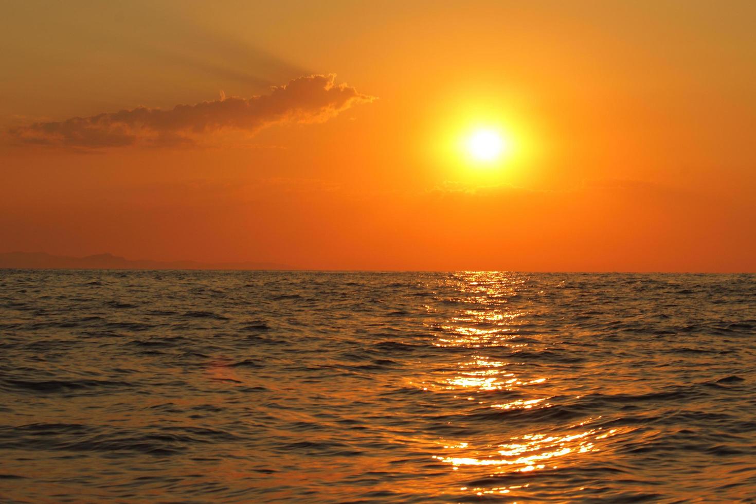 orange heller Sonnenuntergang unter dem Ozean. Sonnenreflexion auf dem Wasser landschaftlich, gelbe Dämmerung, friedliche Naturlandschaft foto