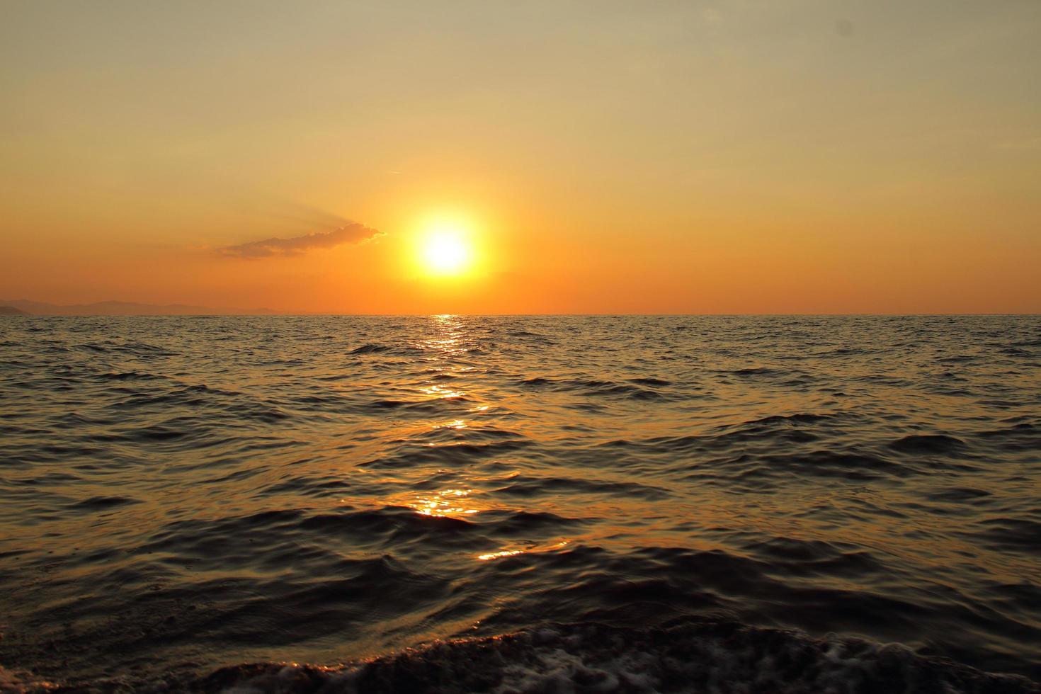 orange heller Sonnenuntergang unter dem Ozean. Sonnenreflexion auf dem Wasser landschaftlich, gelbe Dämmerung, friedliche Naturlandschaft foto