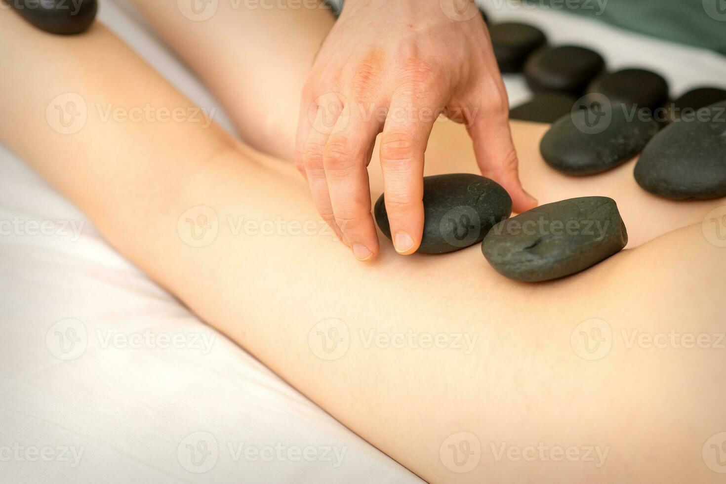 ein Frau bekommen Spa heiß Stein Therapie Beine Massage Verfahren im ein Schönheit Salon. foto