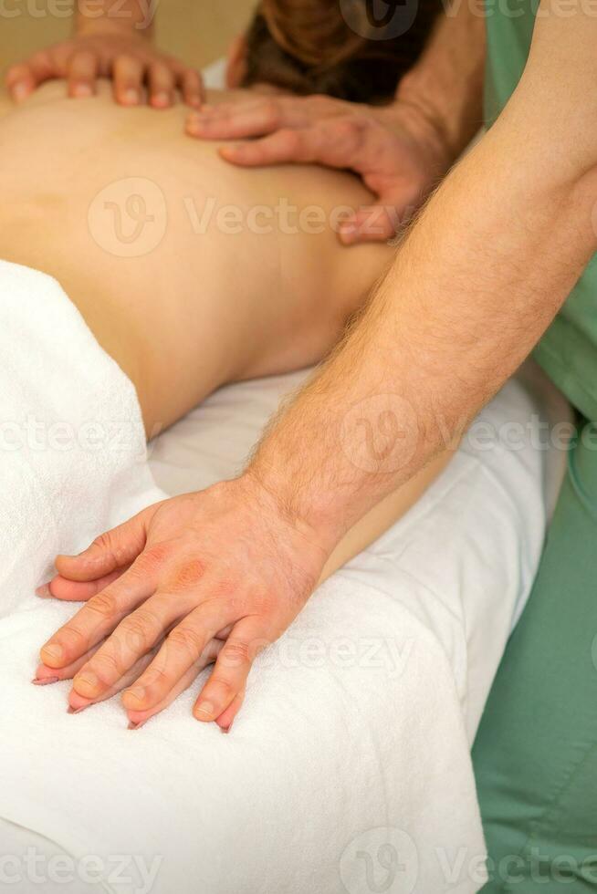zurück und Hände doppelt Massage mit vier Hände von zwei Fachmann Massagegeräte zum ein jung kaukasisch Frau im ein Spa Salon. foto