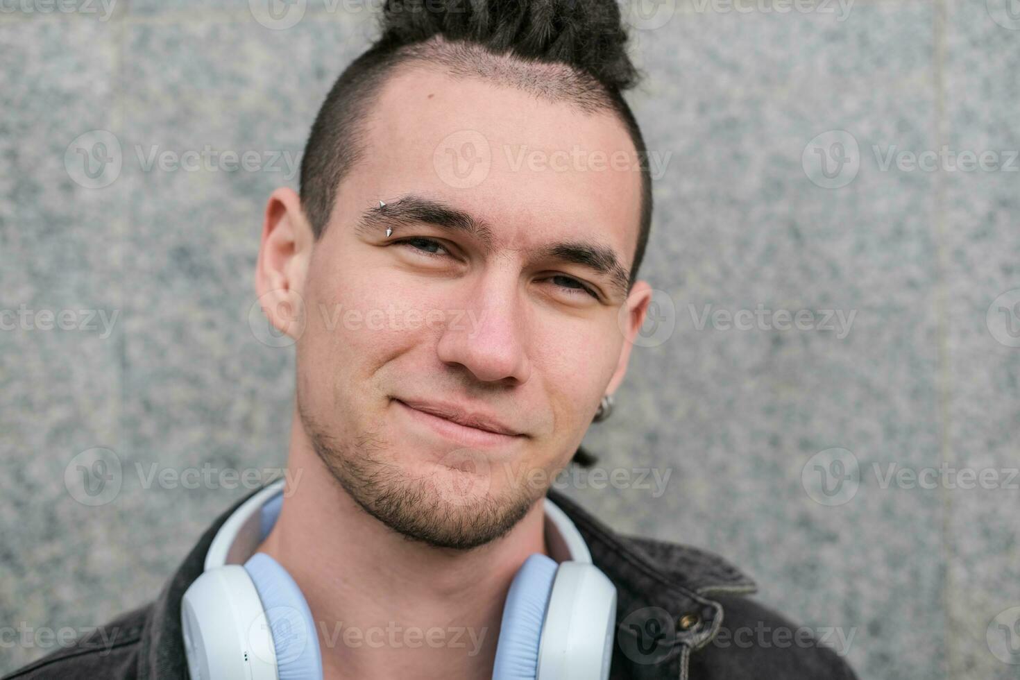 Porträt von ein jung lächelnd Kerl mit Dreadlocks und Piercings foto