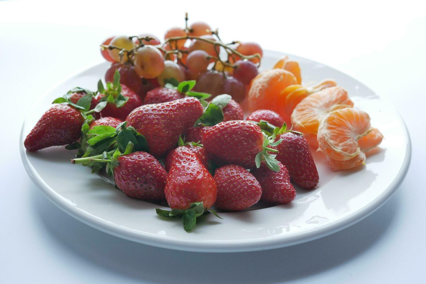Erdbeere. Orange und Traube Obst auf ein Teller foto