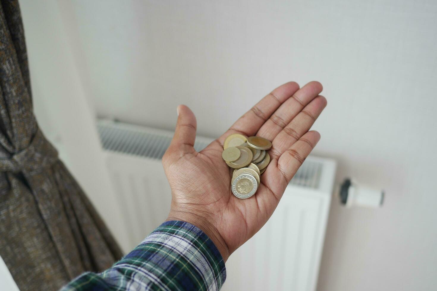 Münzen auf Hand gegen Kühler zu speichern auf Energie Rechnung foto