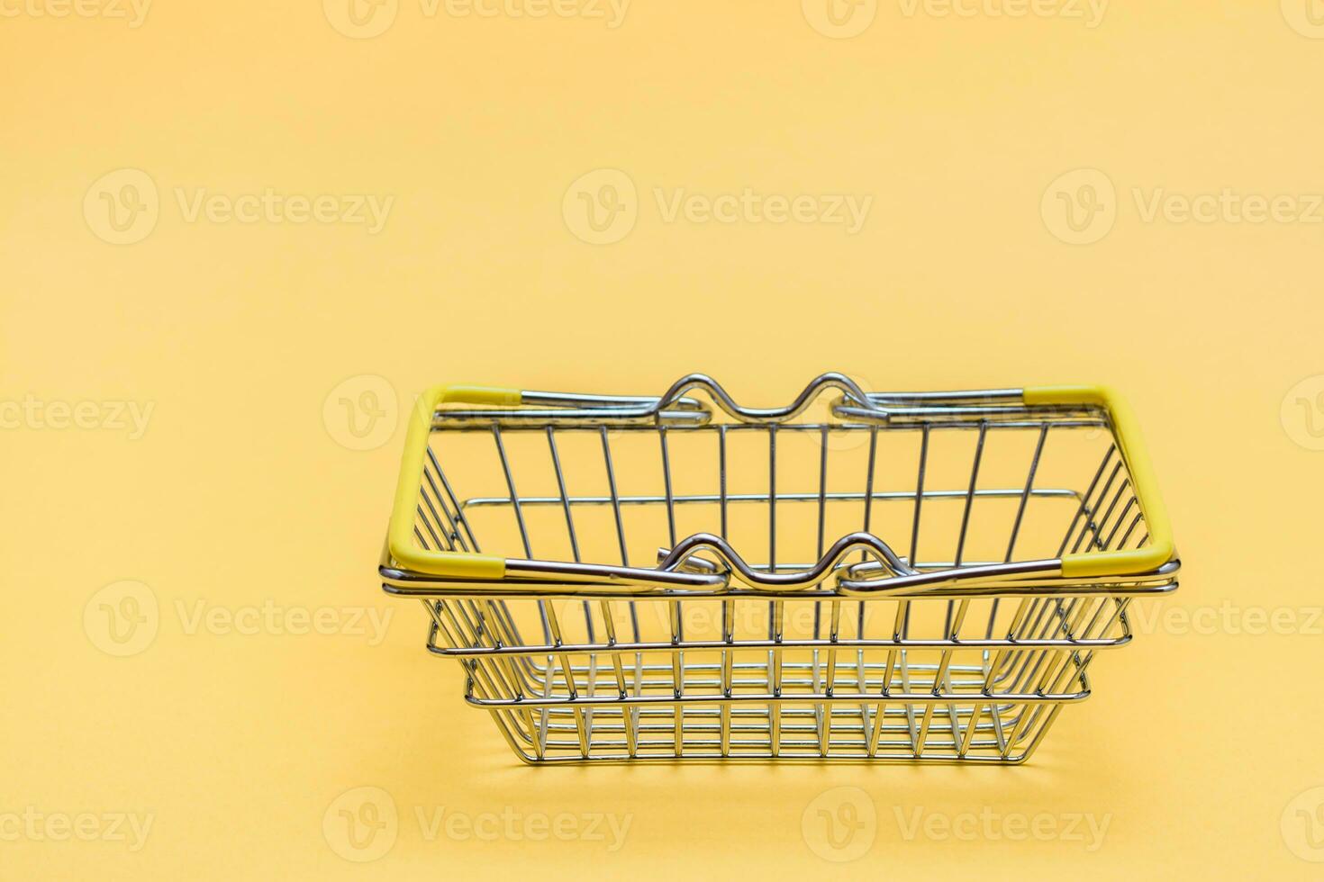Metall Korb zum Einkäufe im das Geschäft auf ein Gelb Hintergrund. schwarz Freitag Geschenk Verkauf. Kopieren Raum foto