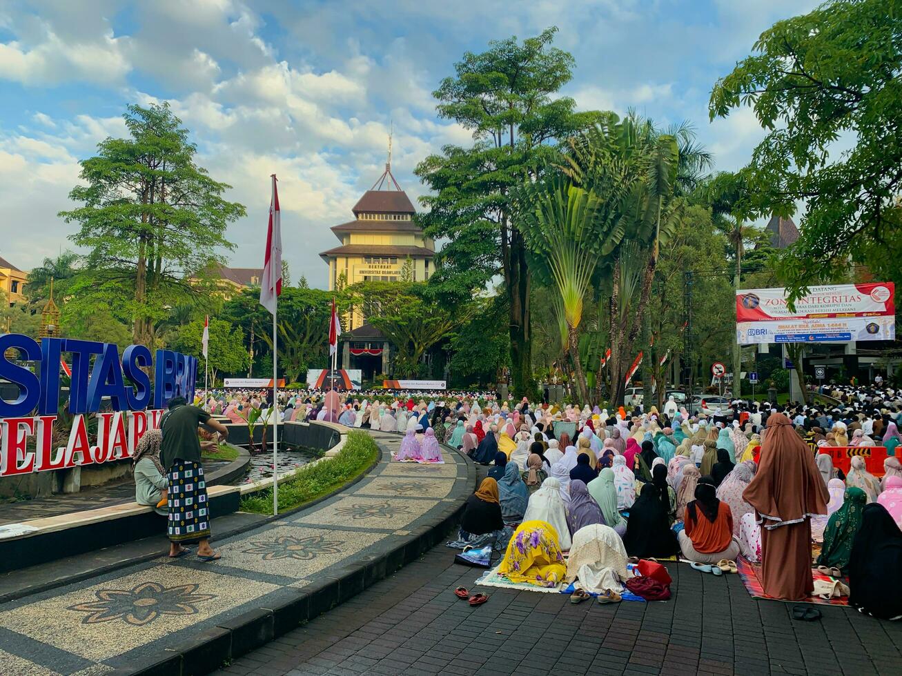 sholat idul fitri. indonesisch Muslim Gemeinschaft sind tun eid al fitr Gebet im draussen Bereich. sholat idul adha im Hochschule Feld mit Wörter meint unabhängig Hochschule foto