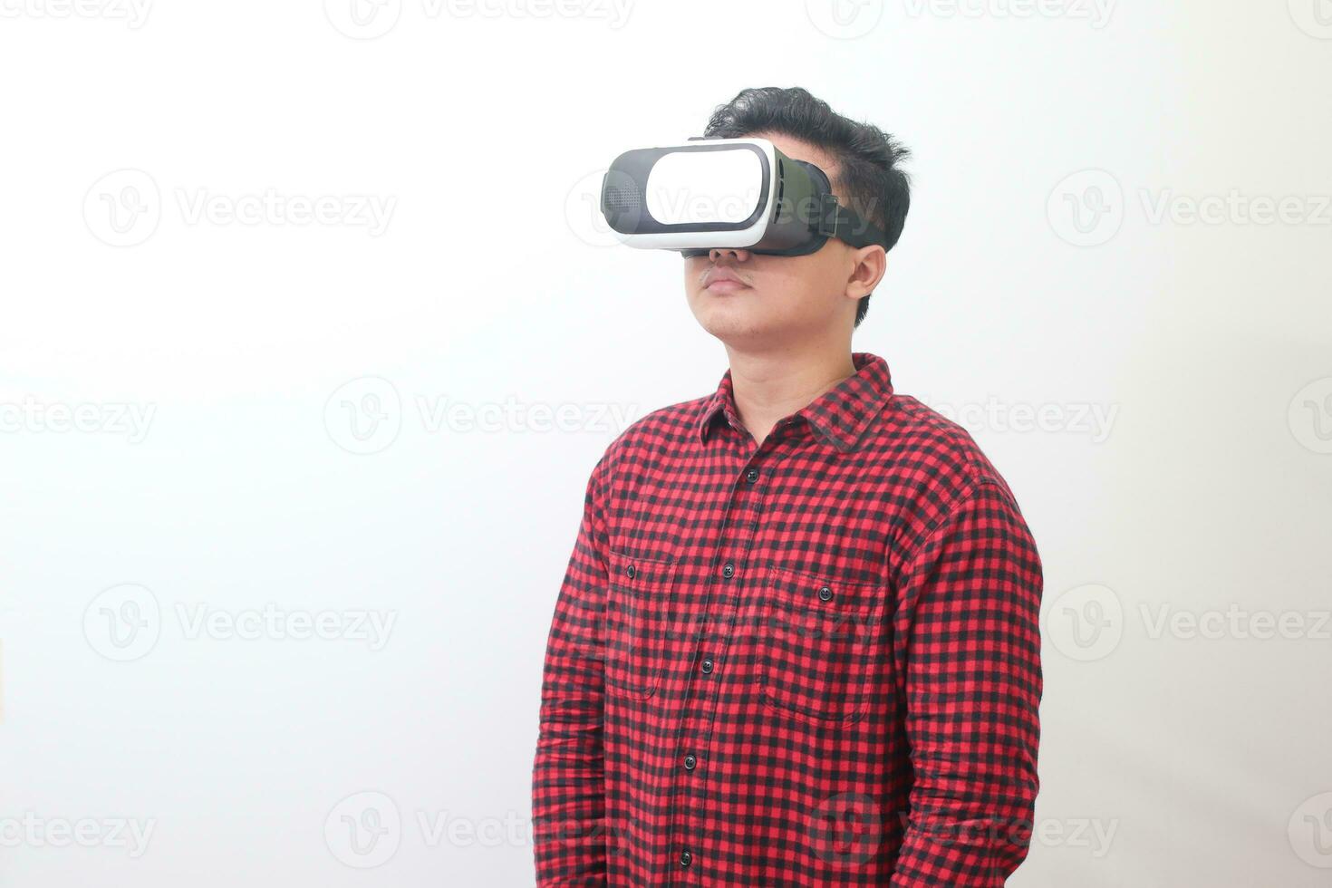 Porträt von asiatisch Mann im rot Plaid Hemd mit virtuell Wirklichkeit vr Brille und suchen hoch. isoliert Bild mit Kopieren Raum auf Weiß Hintergrund foto