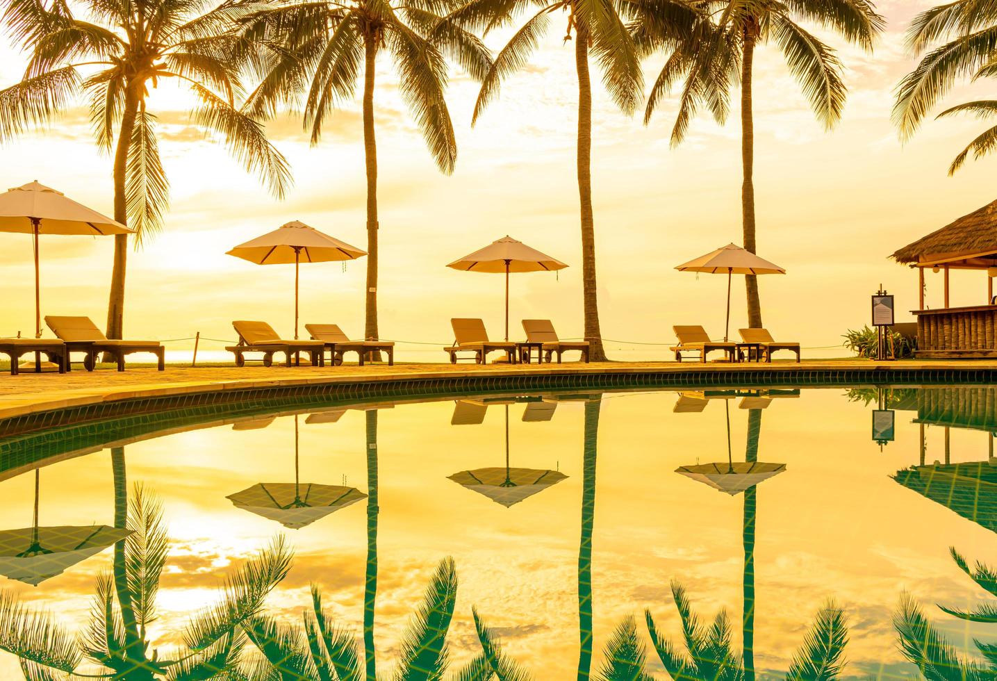 Sonnenschirm und Stuhl um den Pool im Resorthotel für Freizeitreisen und Urlaub in der Nähe von Meer/Ozean-Strand? foto