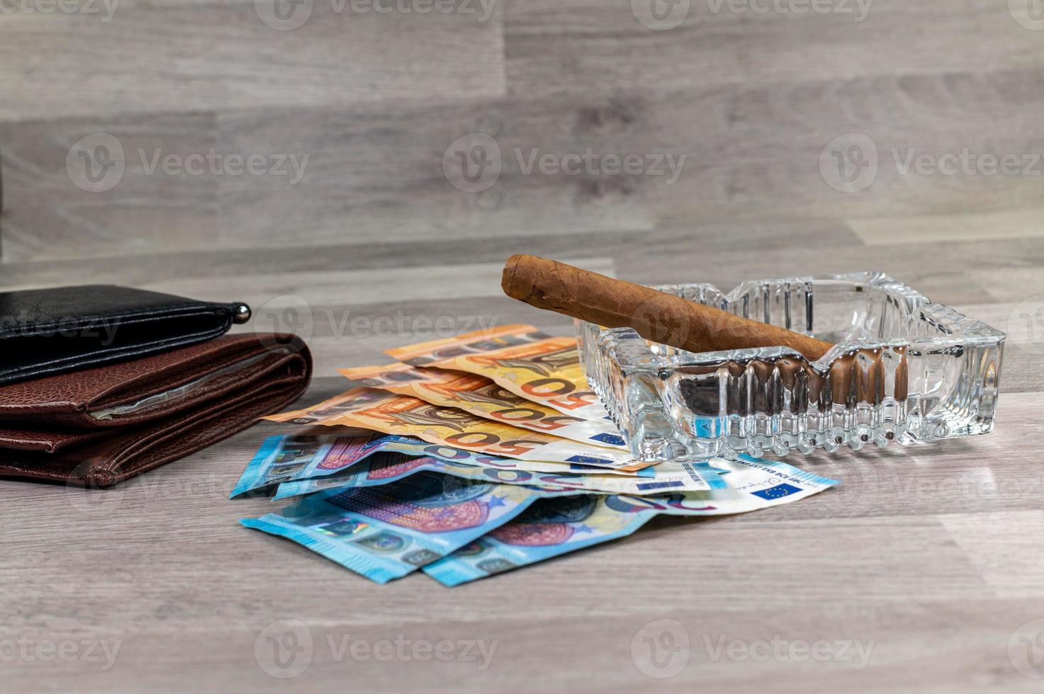 20- und 50-Euro-Banknoten sowie Brieftasche und Zigarre foto