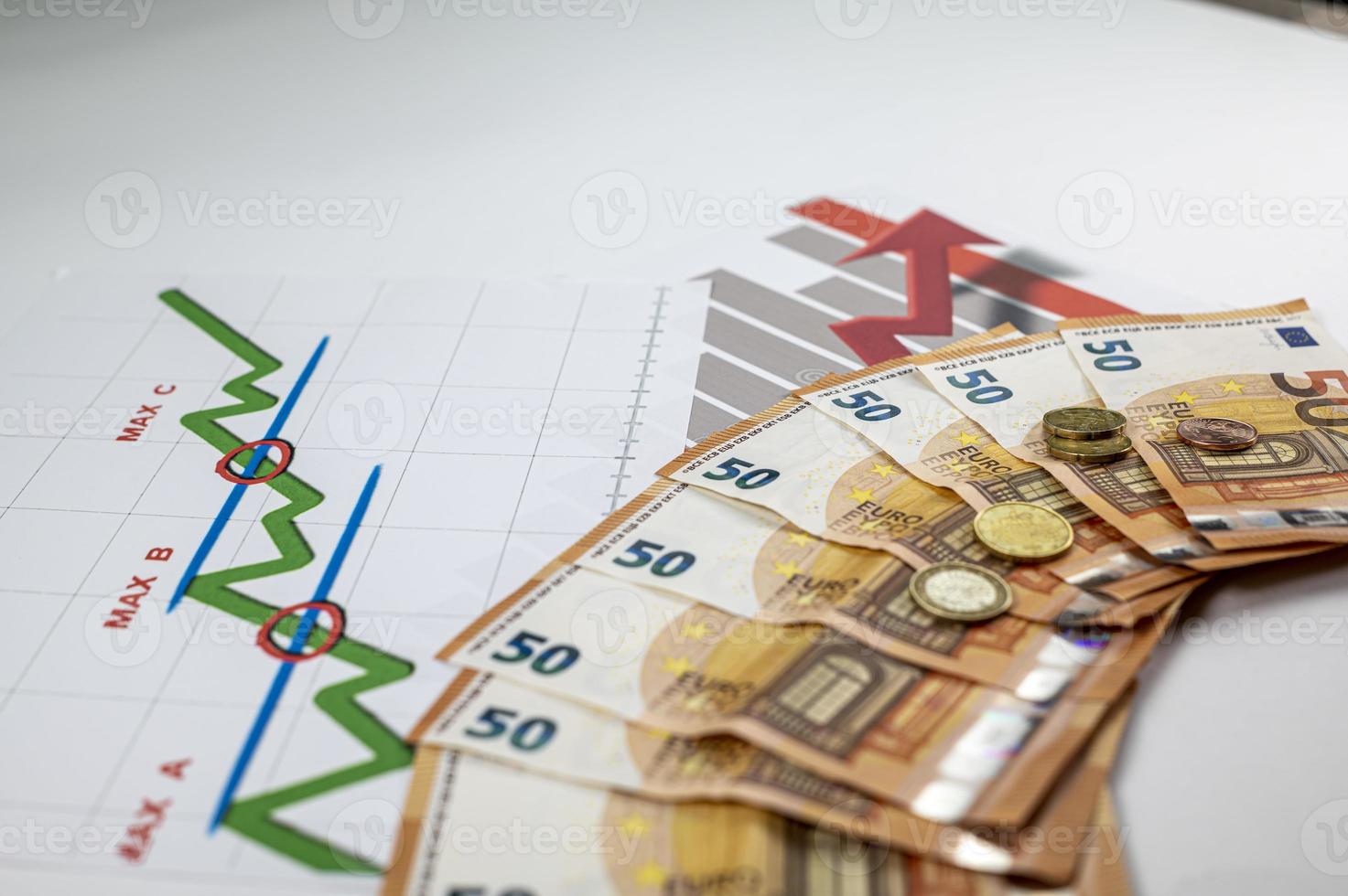 50 Euro-Banknoten, Münzen und Statistiken auf weißem Hintergrund foto