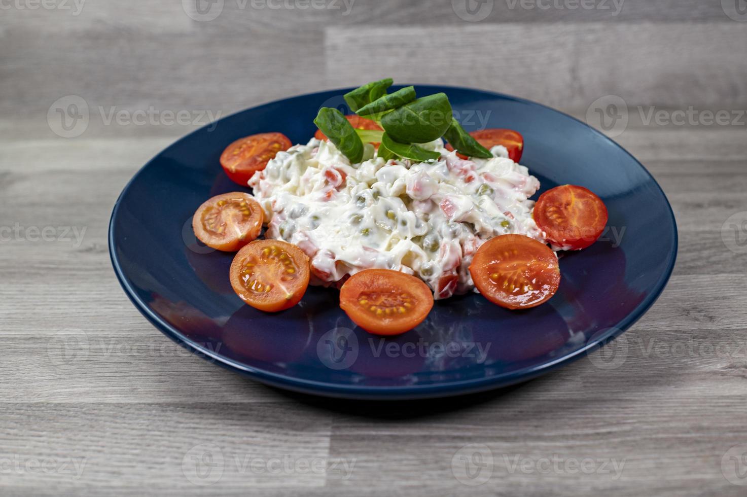 russischer Salat auf blauem Teller foto