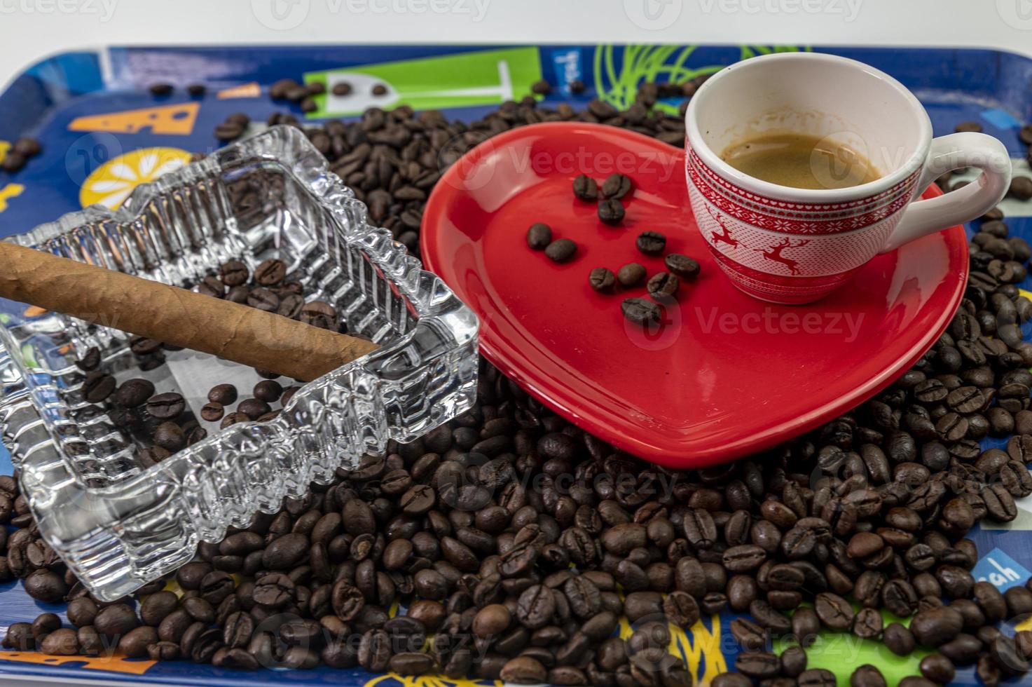 Komposition aus Kaffeebohnen mit herzförmiger Tasse und Untertasse foto