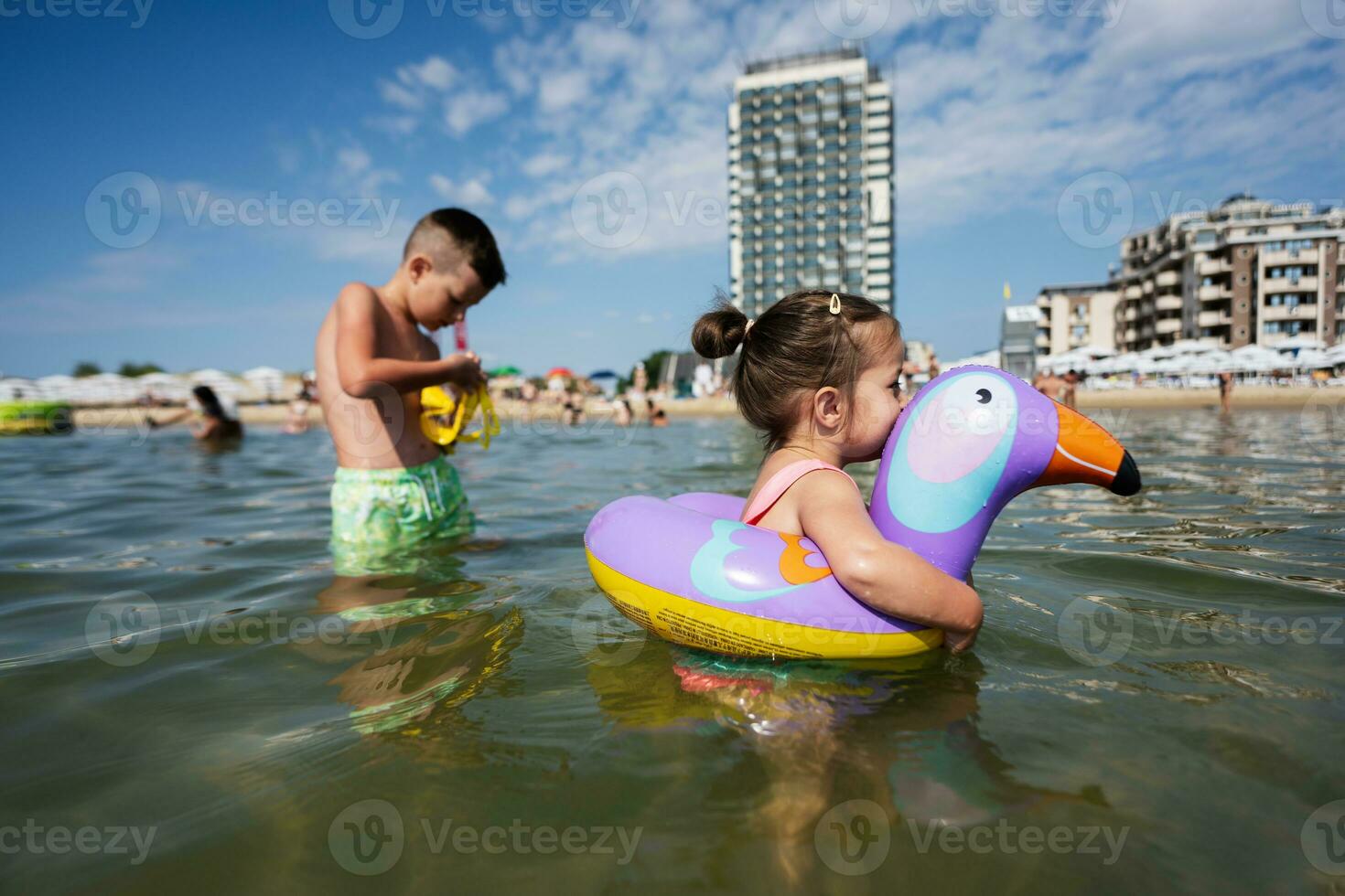 wenig Mädchen Schwimmen im das Meer mit ein aufblasbar Tukan. foto