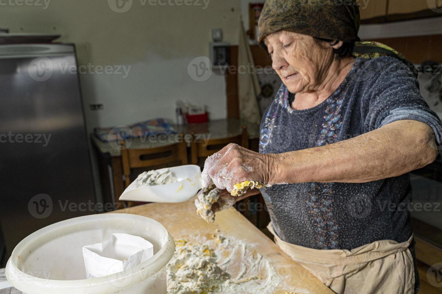 Oma bereitet hausgemachte Pasta zu foto